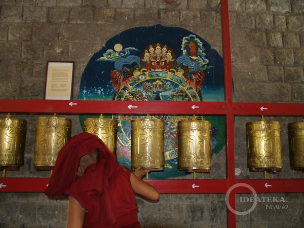 Монах крутит барабаны в центре Norbulingka