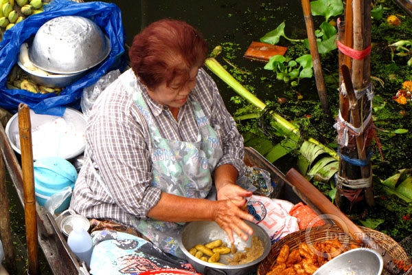 Торговка едой на плавучем рынке в Таиланде